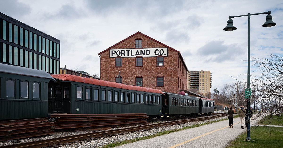 A historic train and the Portland Co. building in Portland, Maine