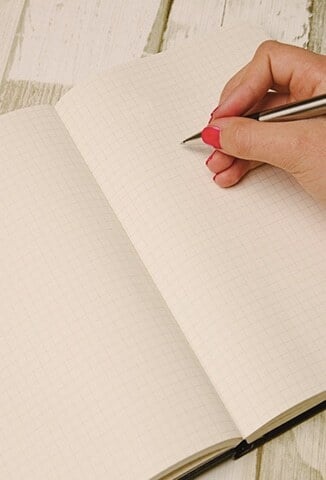 person writing on grid paper