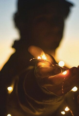 person holding a string of lights