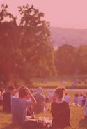 Group of people sitting outside on a hill