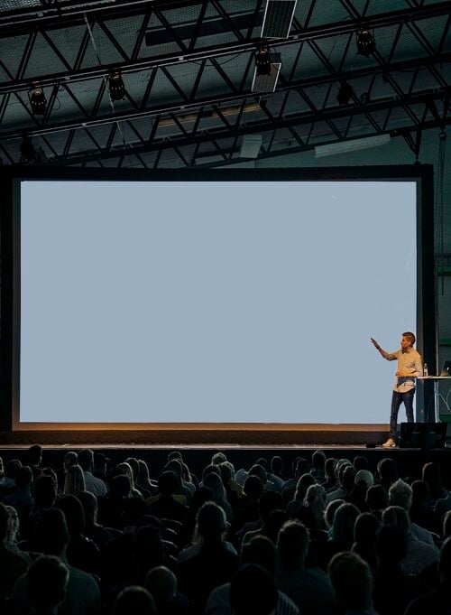 person presenting in front of large crowd
