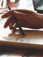 Hand holding pen taking notes in notebook