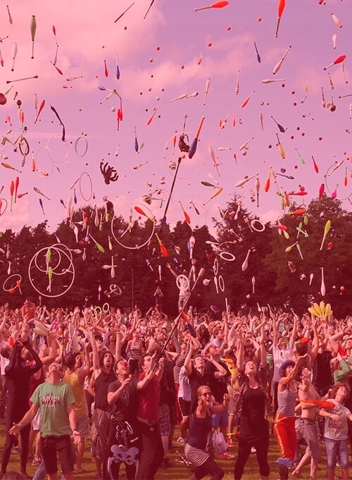 Crowd throwing juggling objects in air