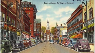 Vintage postcard of Church Street in Burlington, Vermont, lined with shops and parked cars