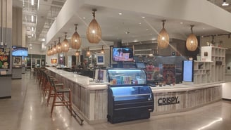 Interior of a bright modern food hall with pendant lights and vendor counters