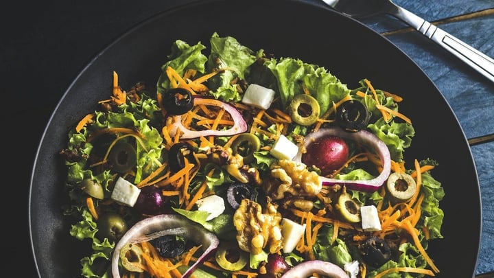 A colorful Mediterranean food spread with shared plates on a wooden table