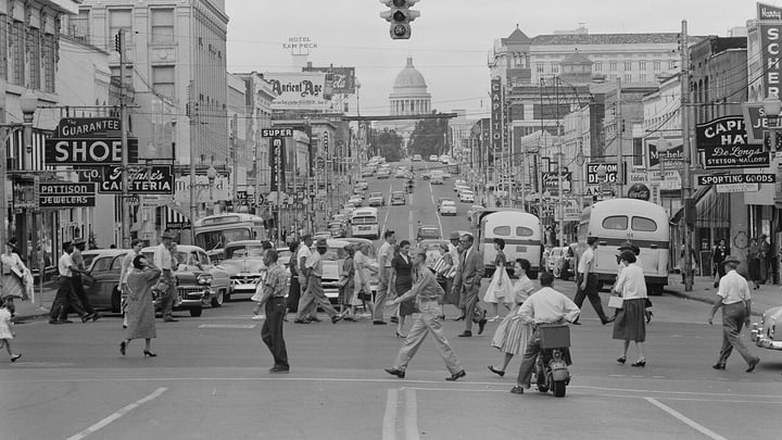 Historic black-and-white photo of shoppers crossing a busy street in downtown Little Rock