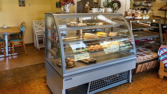 A bakery display case filled with cakes and pastries