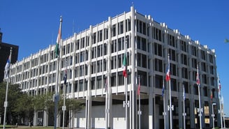 Memphis City Hall, a white modernist office building with a row of flagpoles out front, on Main Street in downtown Memphis