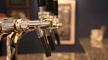 Close-up of shiny beer taps at a taproom bar