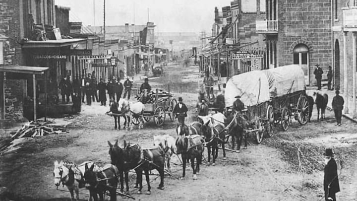 Historic 1870s photo of wagons and mule teams on Last Chance Gulch in Helena, Montana