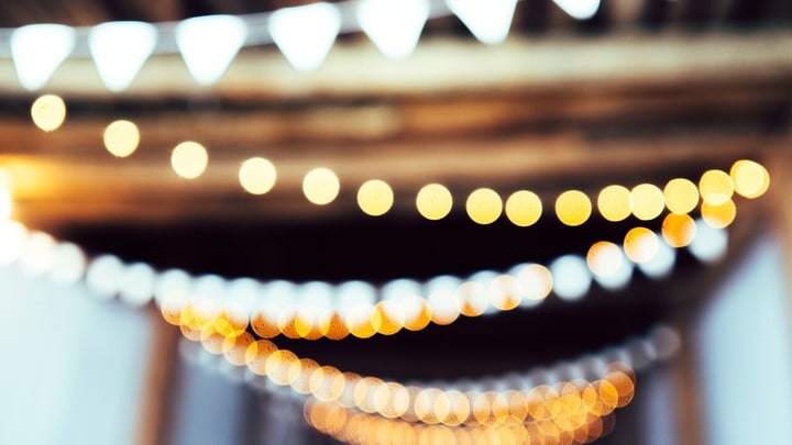 Warm string lights glowing over an event space